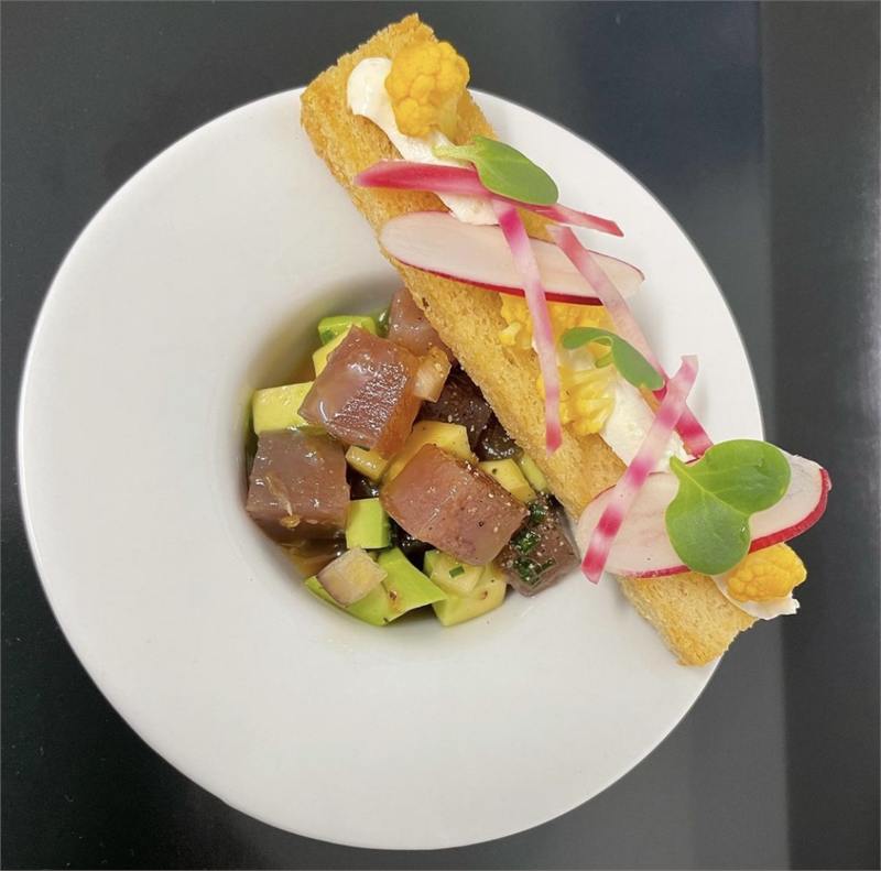 Ceviche de thon, mangue, avocat et radis en assiette creuse