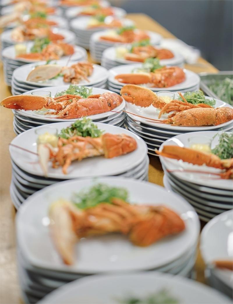 Assiettes de langoustines alignées en cuisine juste avant le service