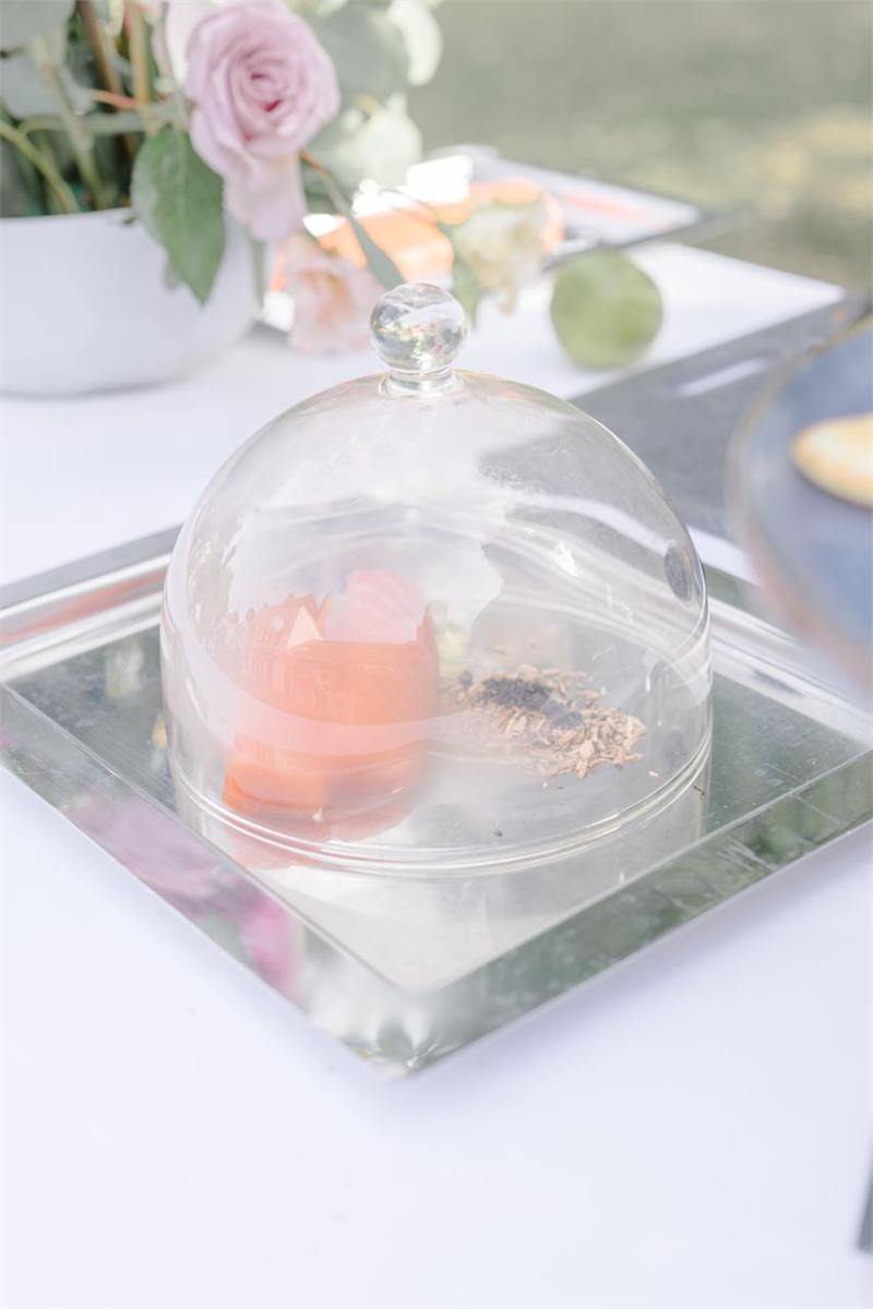 Mise en bouche présentée sous cloche de verre sur miroir